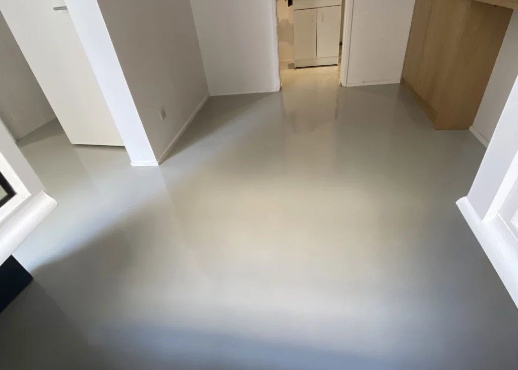 Vue d'un sol en béton ciré lisse et moderne dans une pièce lumineuse.