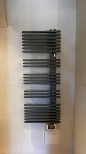 Mur de salle de bain en béton ciré avec sèche-serviettes, réalisation BTONBYSANDRA