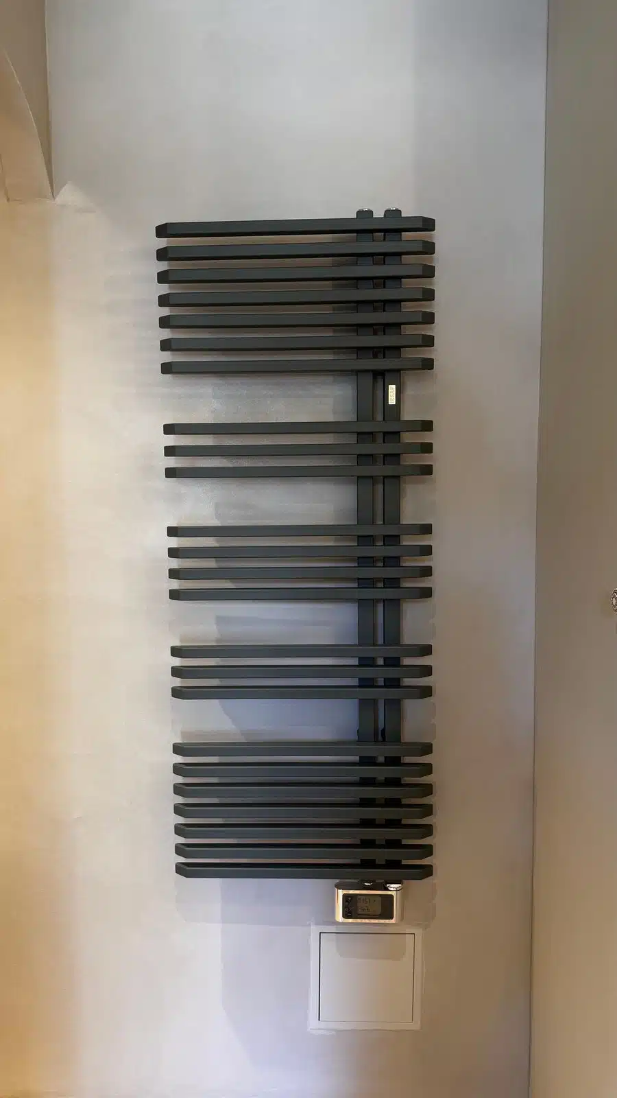 Mur de salle de bain en béton ciré avec sèche-serviettes, réalisation BTONBYSANDRA