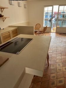 Cuisine avec plan de travail en béton ciré et tomettes