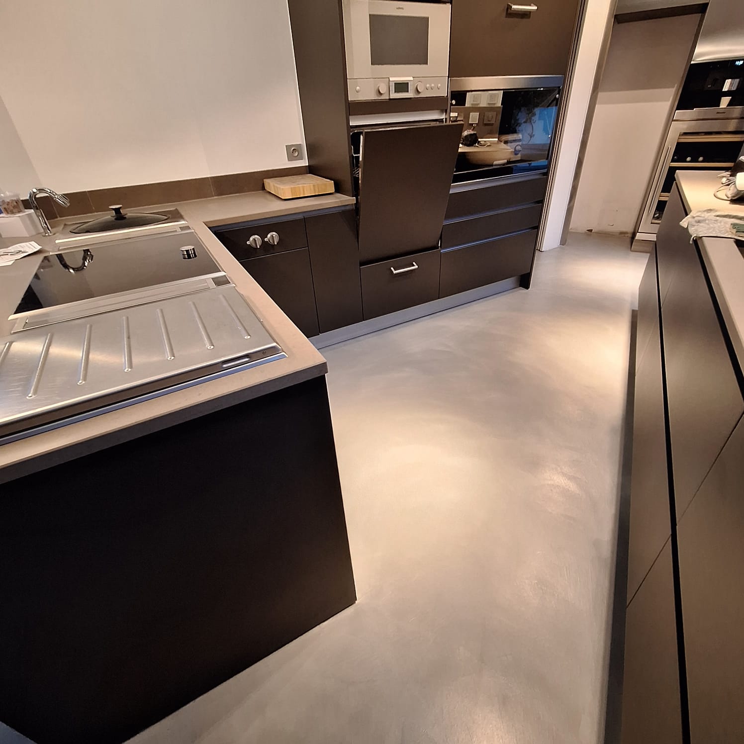 Cuisine avec sol en béton ciré de couleur noire et meubles modernes