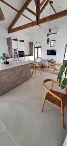 Intérieur d'une cuisine avec sol en béton ciré et poutres en bois
