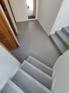 Escalier avec marches en béton ciré gris dans une entrée