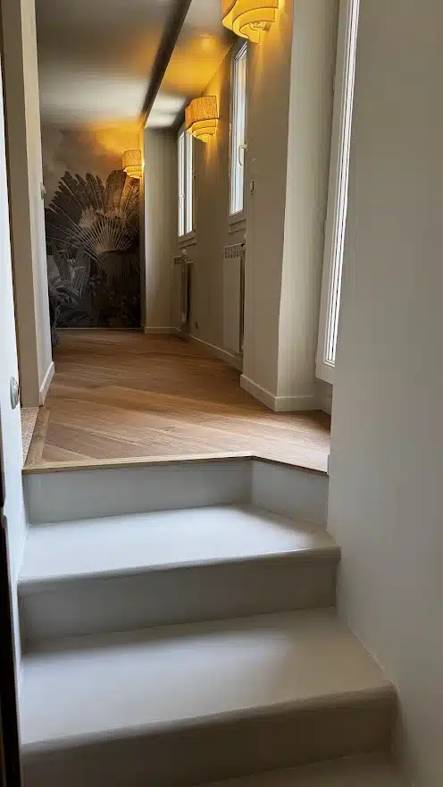 Escalier en béton ciré avec mur décoré et éclairage doux