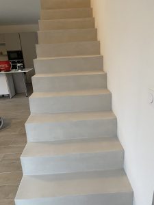 Escalier suspendu en béton ciré après pose, avec murs clairs.
