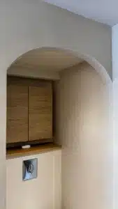 Vue d'un coin de salle de bain avec béton ciré et mobilier en bois
