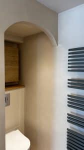 Salle de bain avec mur en béton ciré et meuble en bois