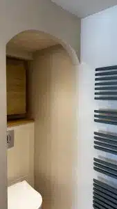 Salle de bain avec mur en béton ciré et meuble en bois