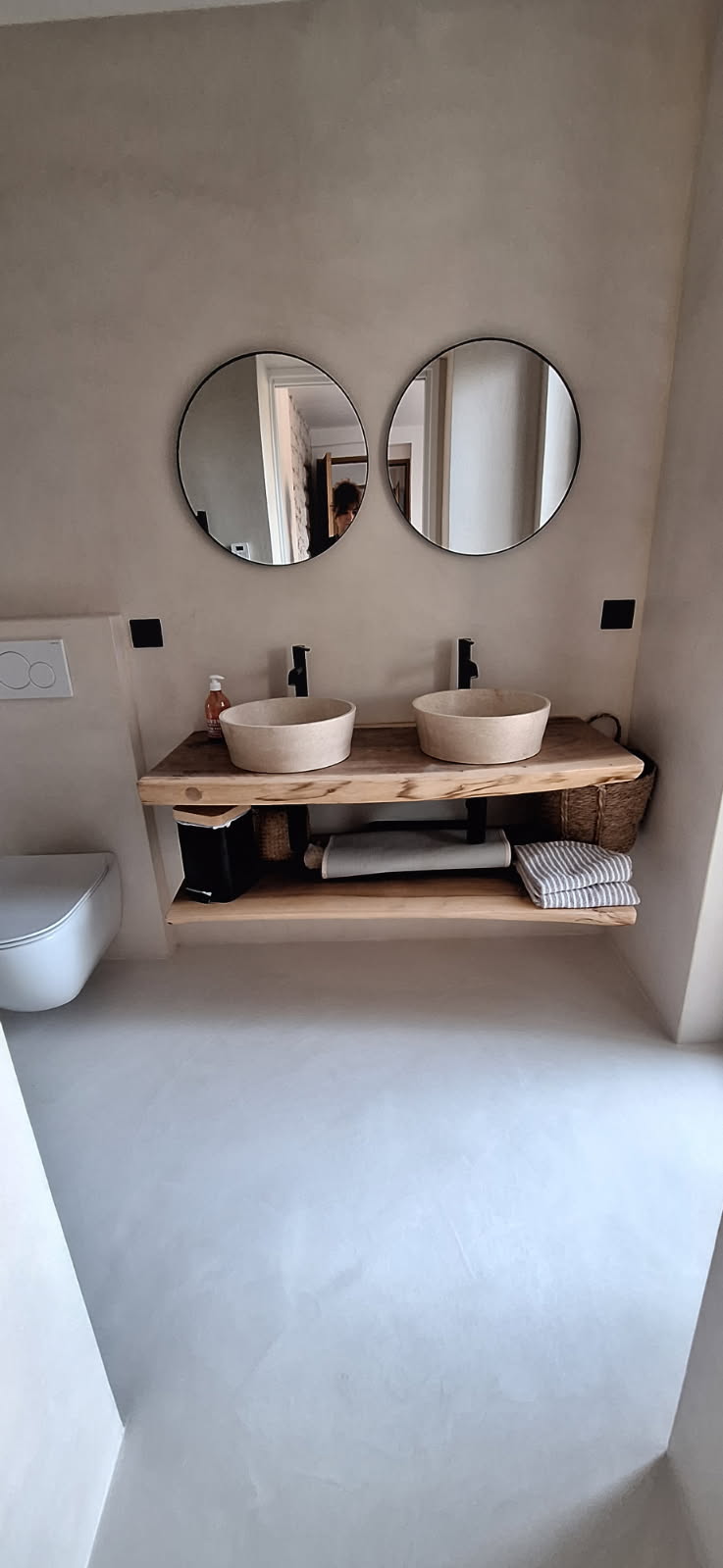 Salle de bain avec double vasque en béton ciré et miroir rond