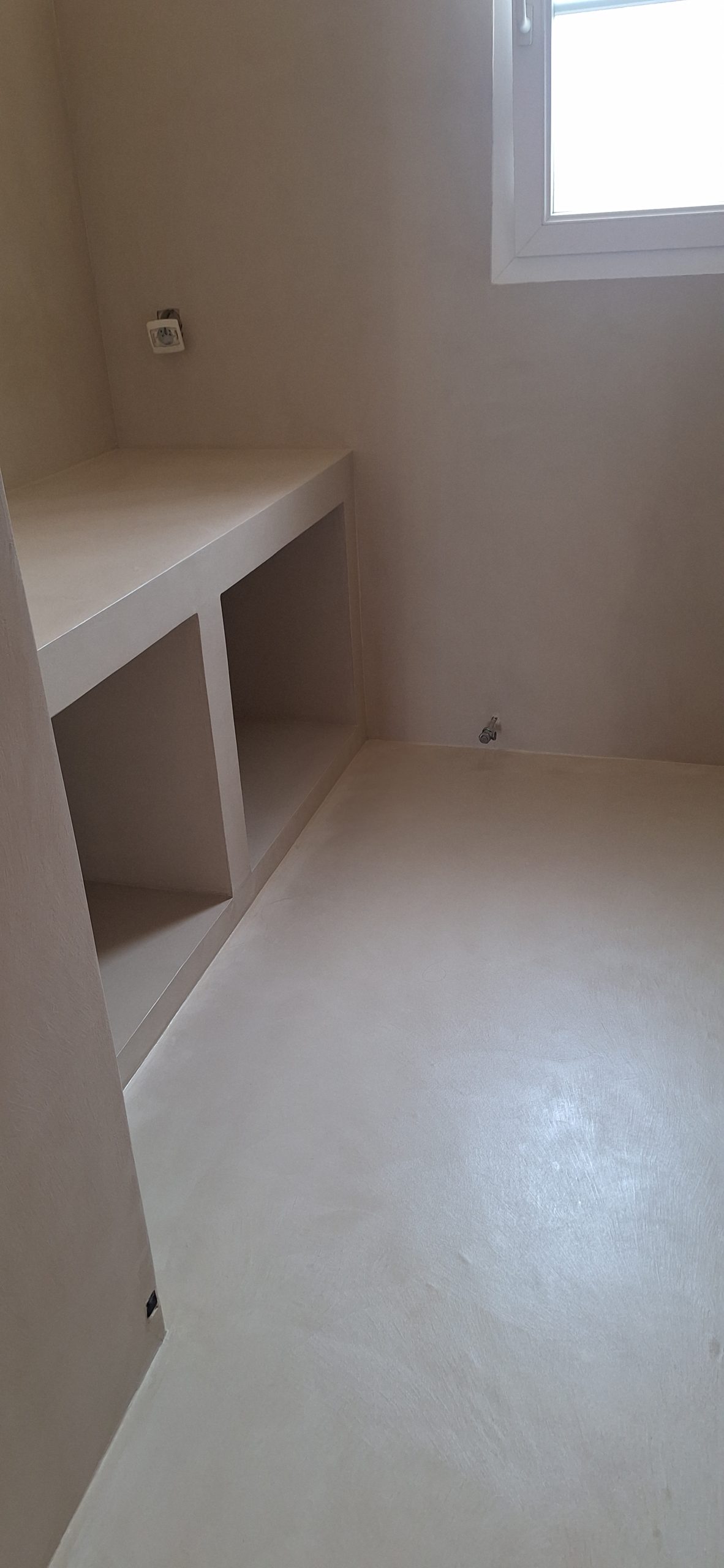Salle de bain avec revêtement en béton ciré et meuble intégré