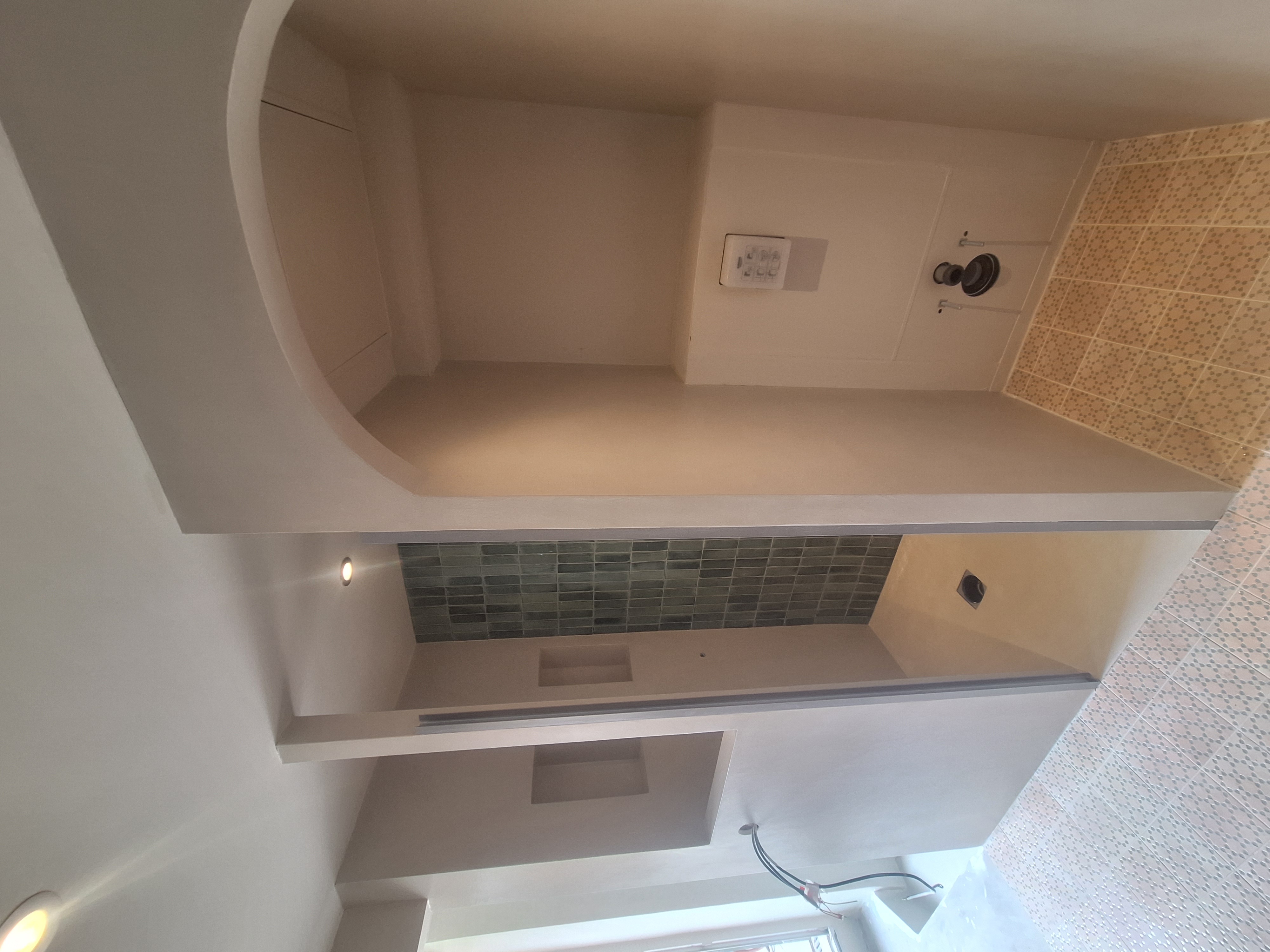 Salle de bain avec mur en béton ciré et niche zellige