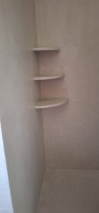 Étagères en béton ciré dans une douche moderne.