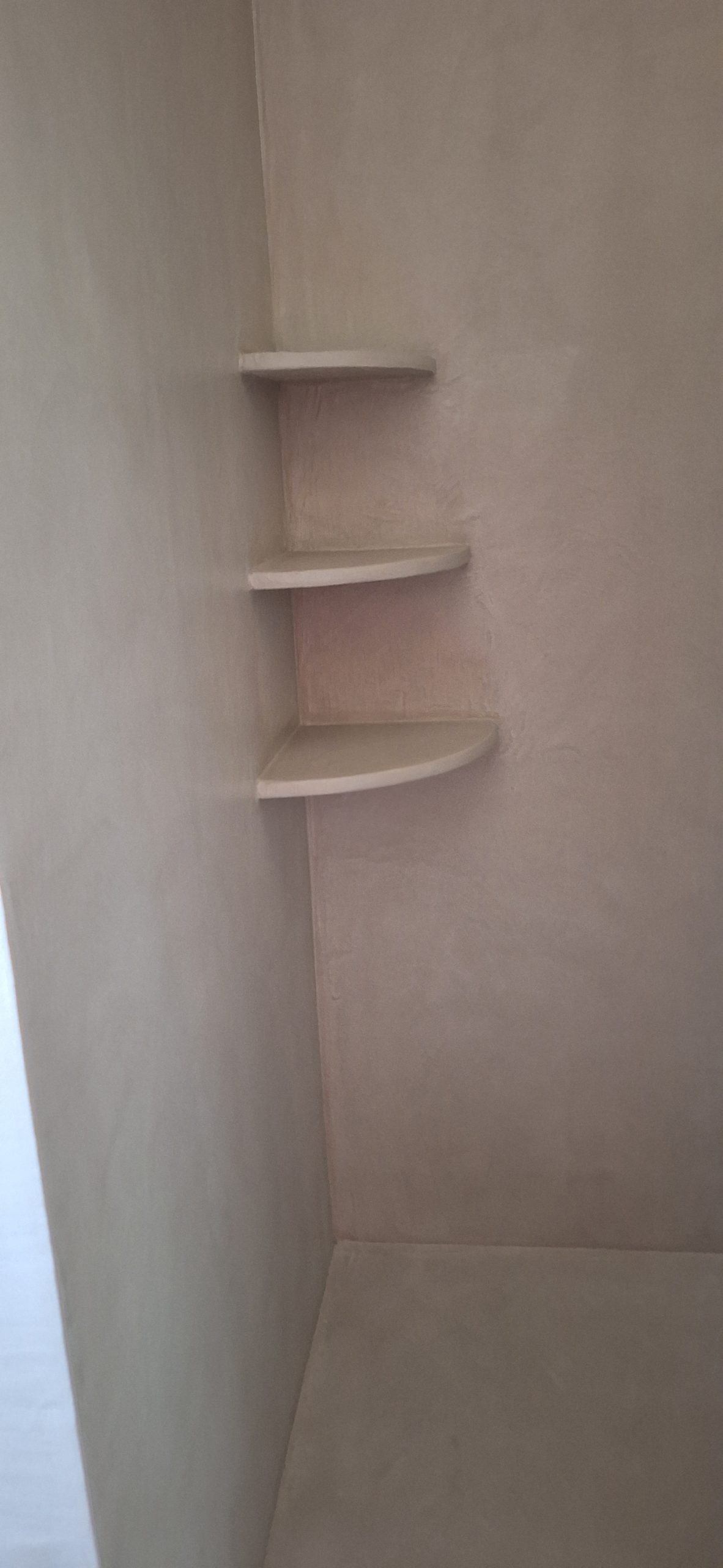 Étagères en béton ciré dans une douche moderne.