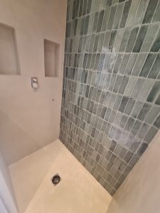 Vue d'une douche avec murs en béton ciré et carrelage zellige