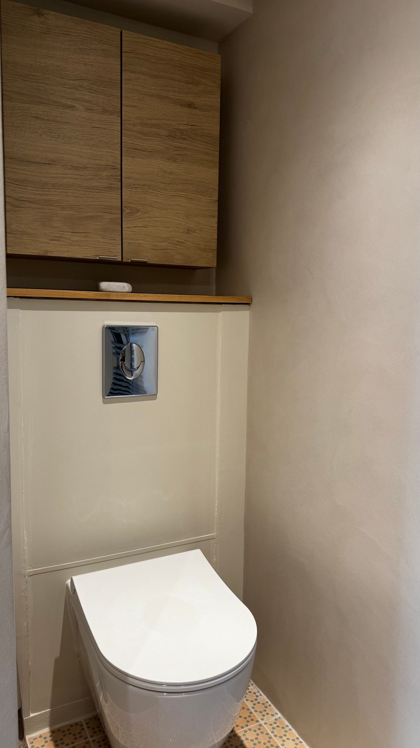 Toilettes modernes avec mur en béton ciré et meuble en bois.