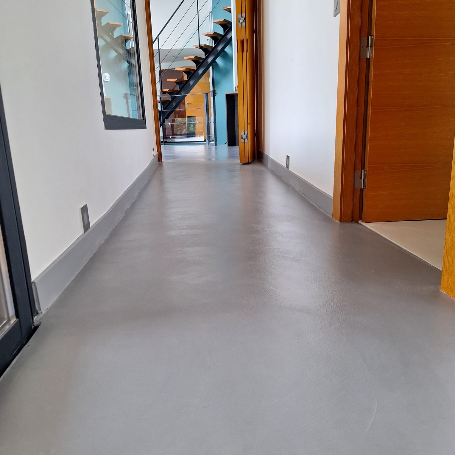 Couloir lumineux avec un sol en béton ciré continu sans joint, teinte claire — réalisation BTONBYSANDRA en PACA