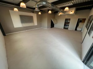 Sol en béton ciré dans une pièce lumineuse avec éclairage suspendu