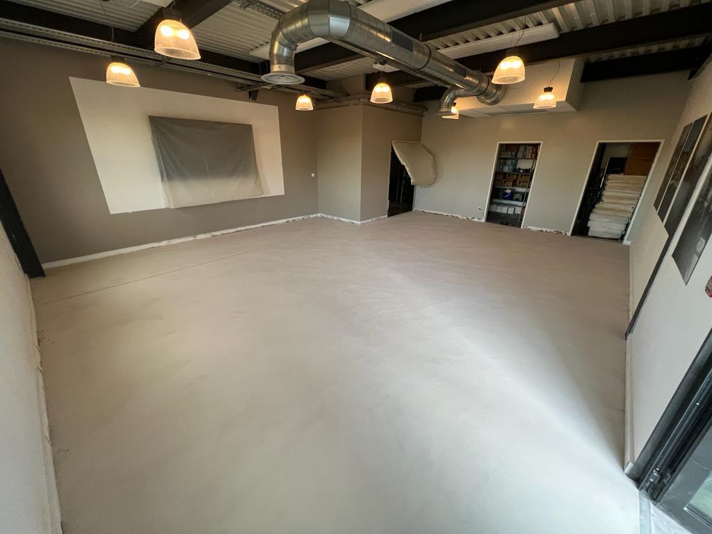 Sol en béton ciré dans une pièce lumineuse avec éclairage suspendu