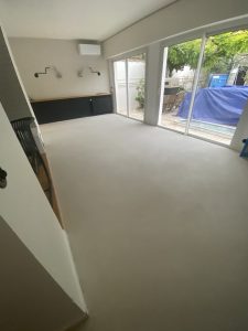 Intérieur d'une pièce avec un sol en béton ciré et des fenêtres