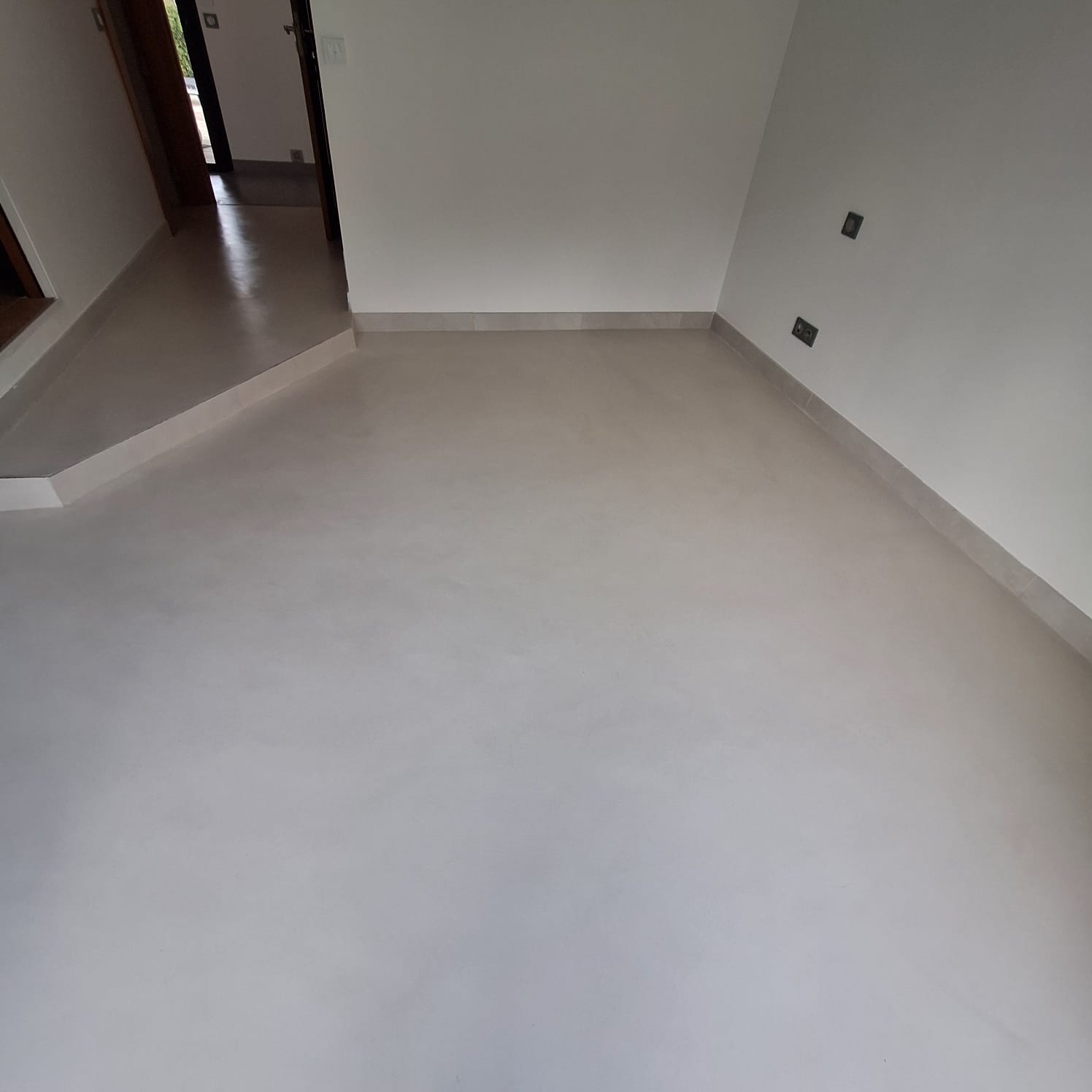 Sol en béton ciré dans un couloir avec une finition lisse et claire.