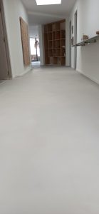 Sol en béton ciré dans un hall moderne avec des étagères.