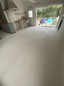 Sol en béton ciré dans une pièce avec vue sur l'extérieur