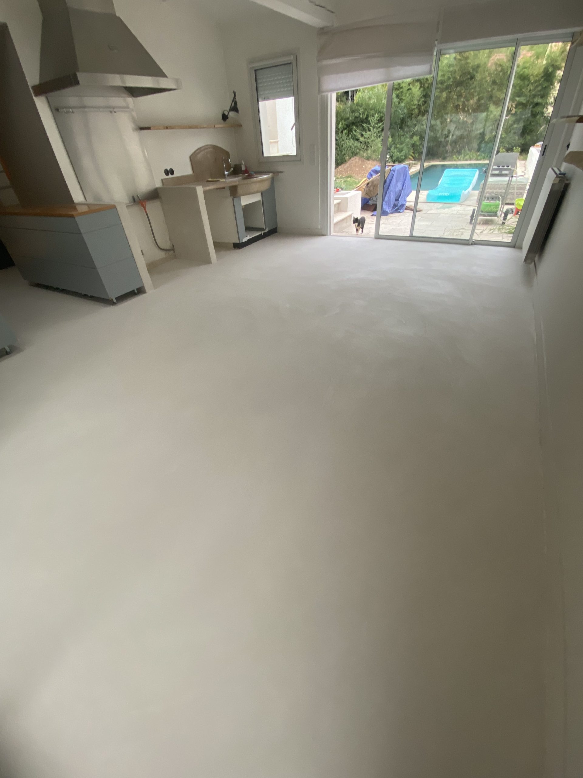 Sol en béton ciré dans une pièce avec vue sur l'extérieur