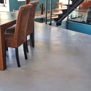 Sol en béton ciré dans une salle à manger avec chaises