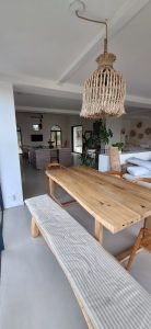 Intérieur d'une salle à manger avec un sol en béton ciré et une suspension en osier.