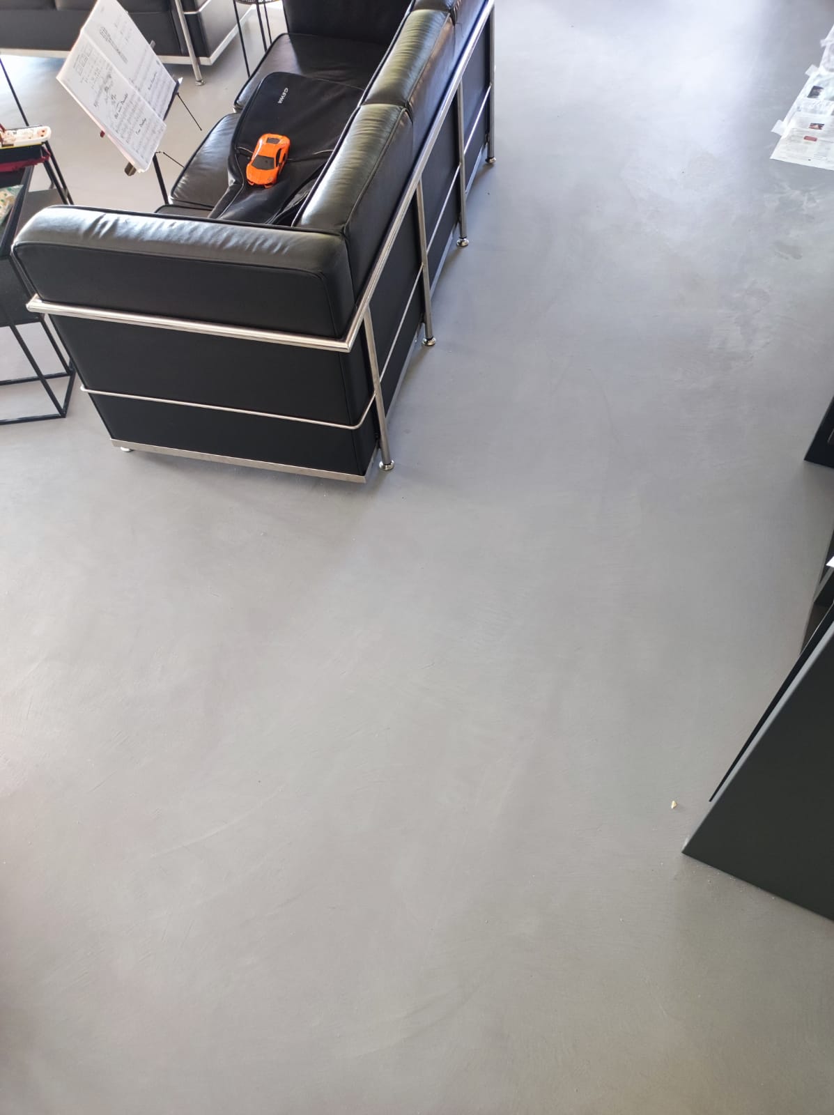 Sol en béton ciré dans un salon avec canapé Le Corbusier et mobilier design