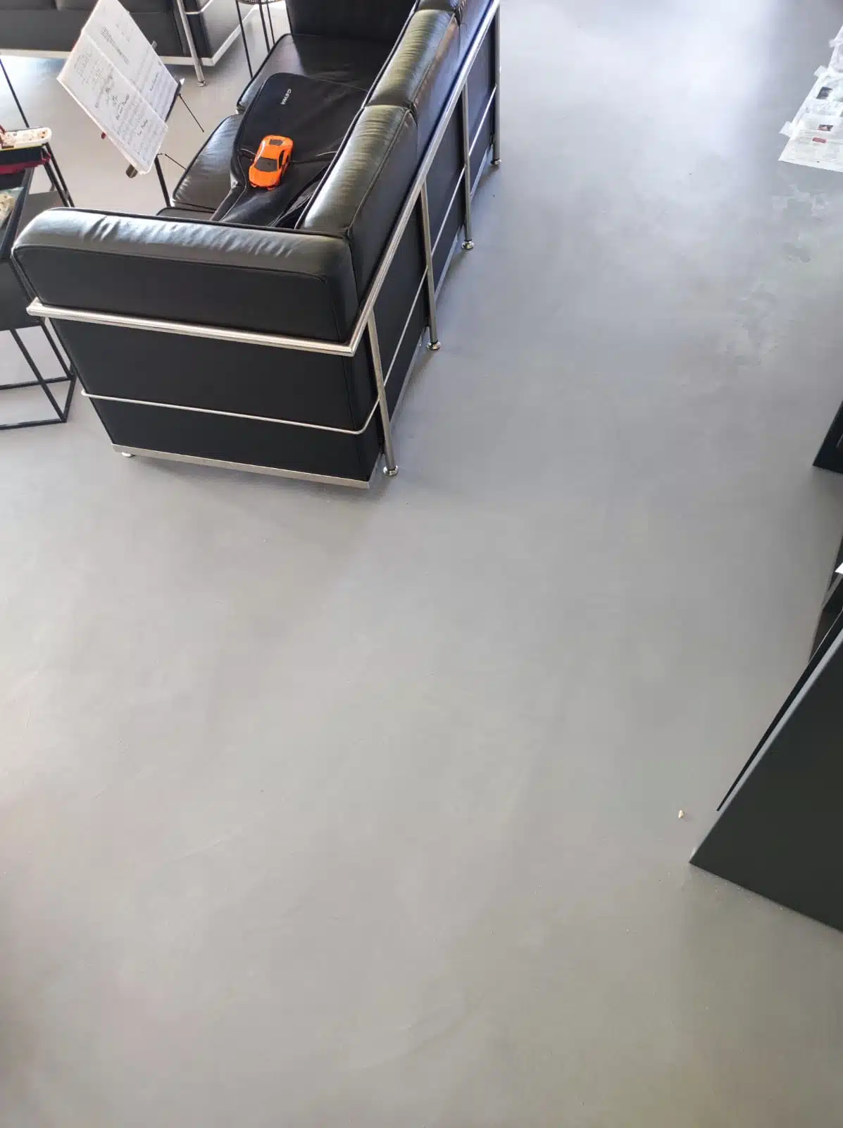 Sol en béton ciré dans un salon avec canapé Le Corbusier et mobilier design