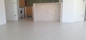 Sol en béton ciré dans un salon avec cuisine ouverte