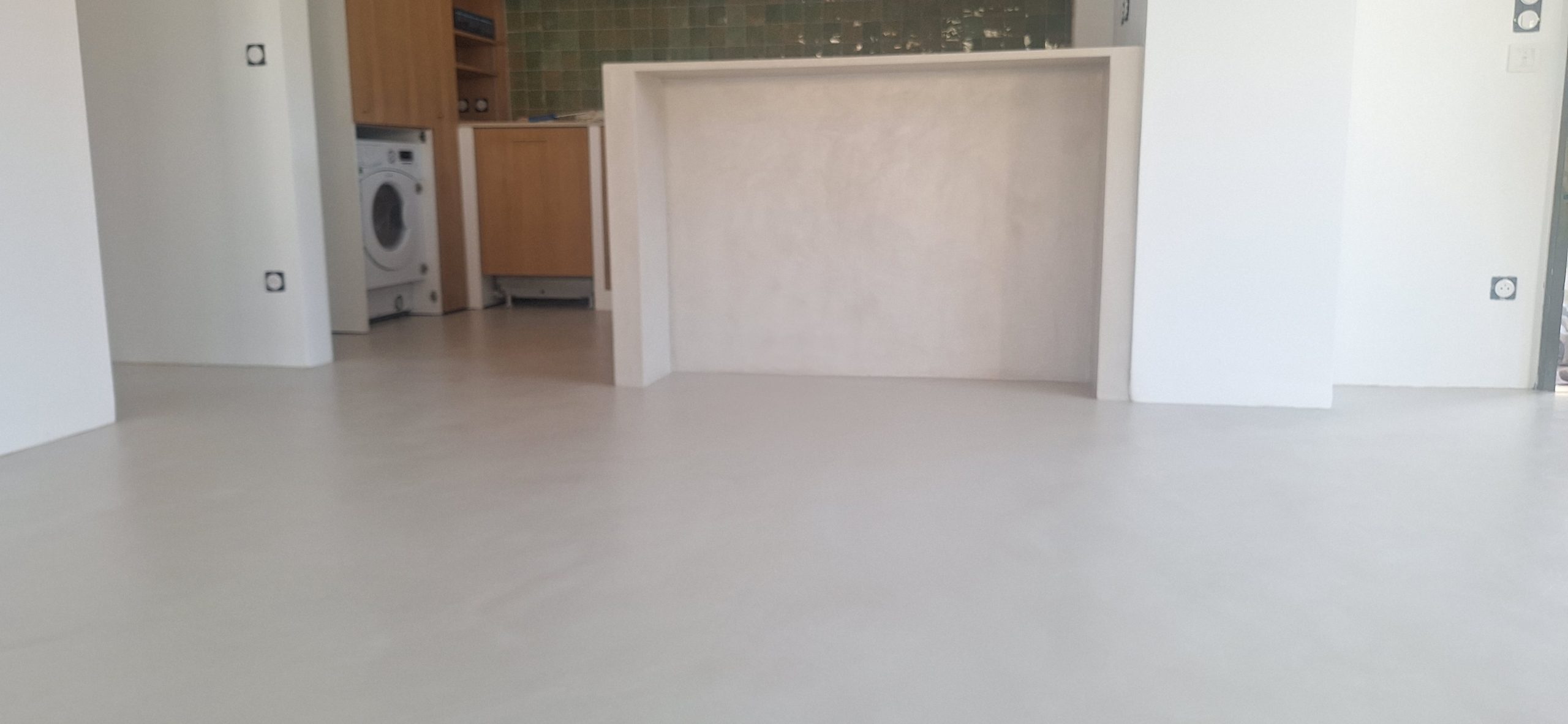 Sol en béton ciré dans un salon avec cuisine ouverte