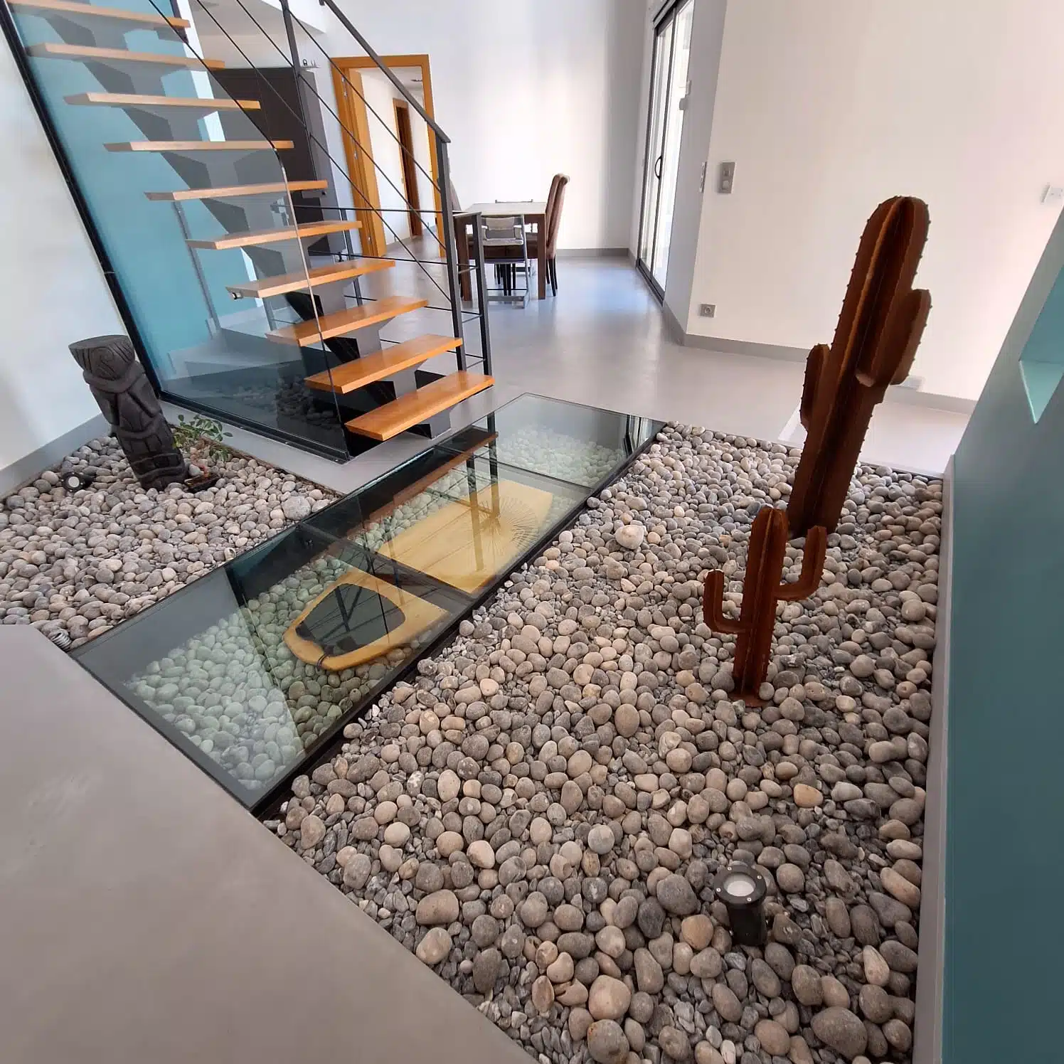 Sol en béton ciré dans un salon avec escalier et galets décoratifs