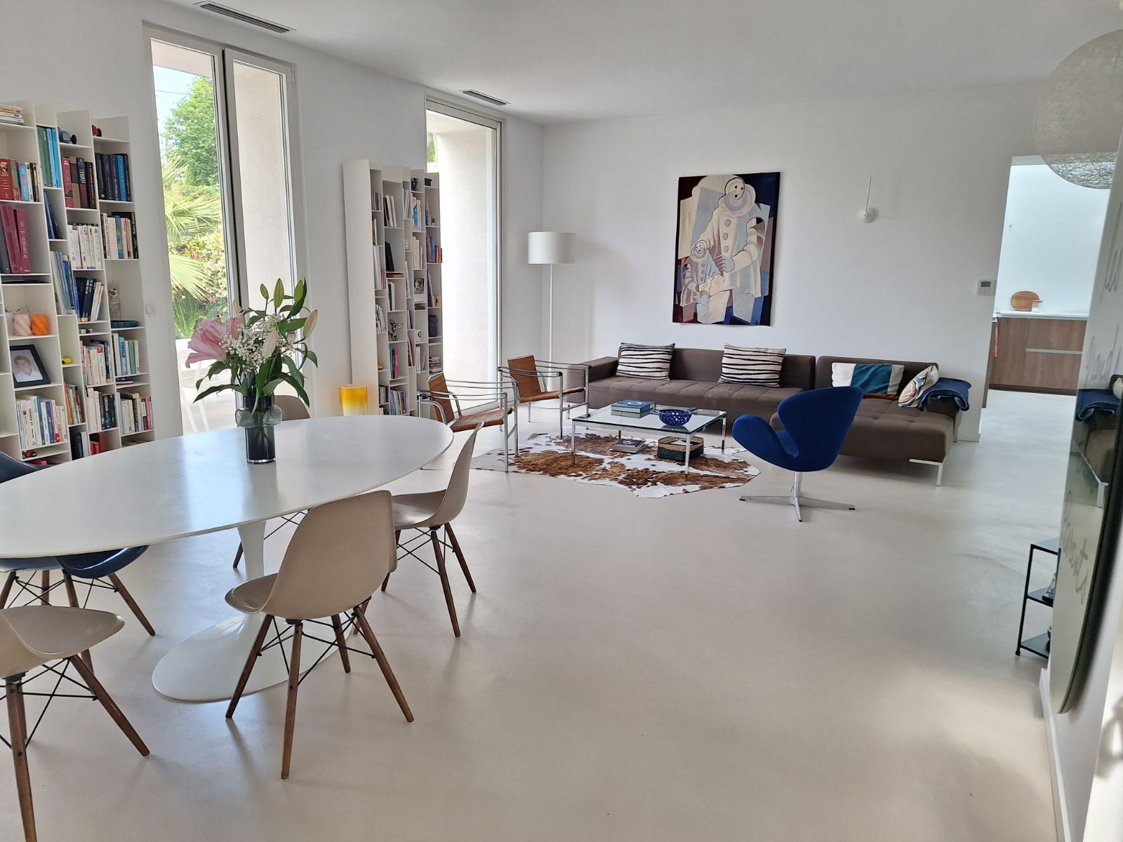 Vue d'un salon moderne avec un sol en béton ciré et des meubles contemporains.