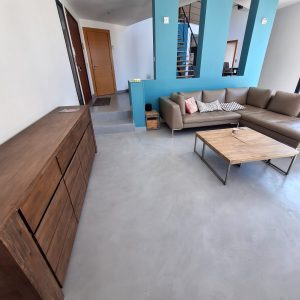 Salon moderne avec sol en béton ciré et canapé en cuir