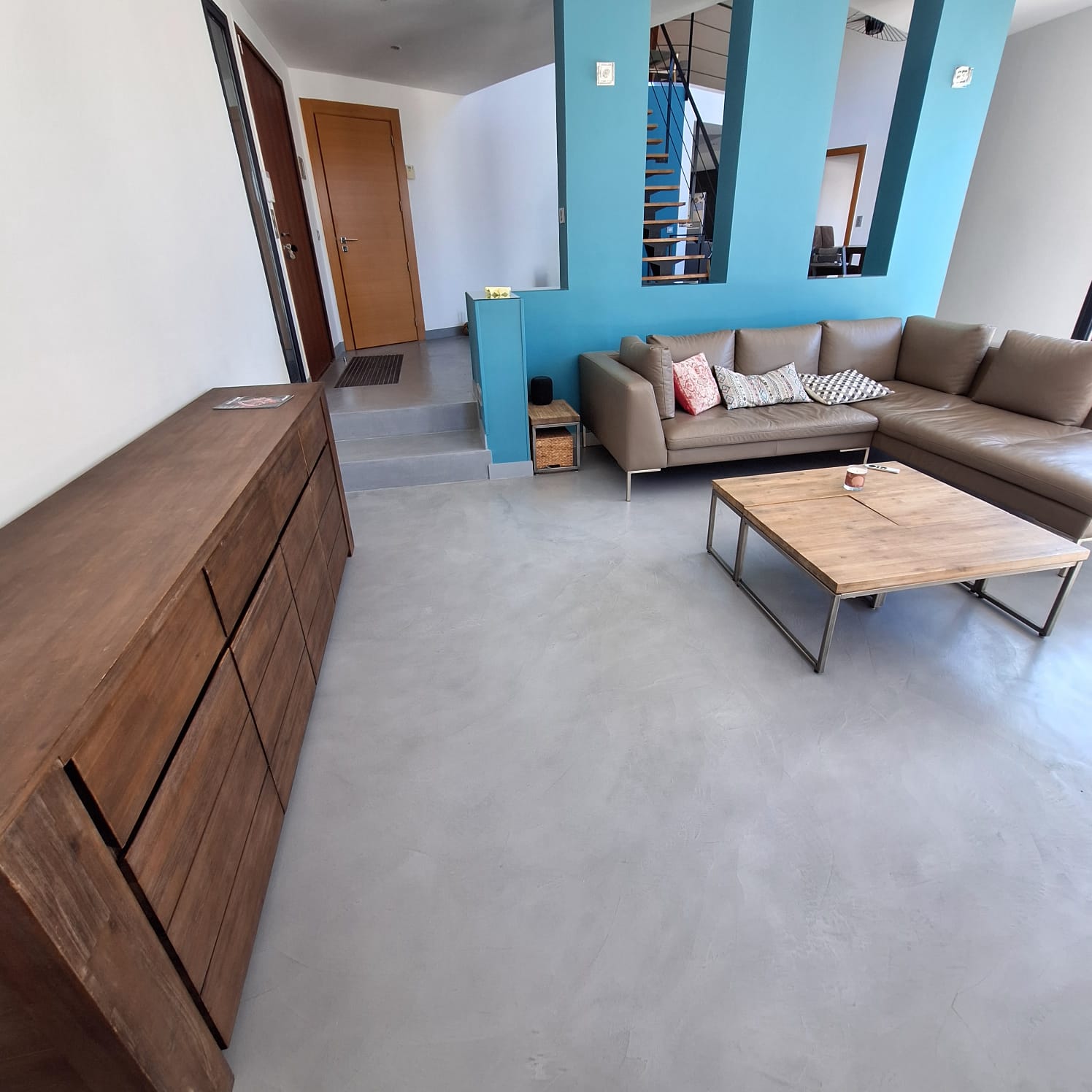 Salon moderne avec sol en béton ciré et canapé en cuir