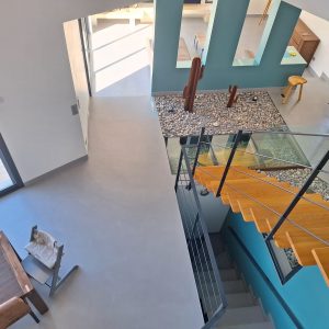 Vue plongeante d'un escalier avec un sol en béton ciré et des décorations modernes